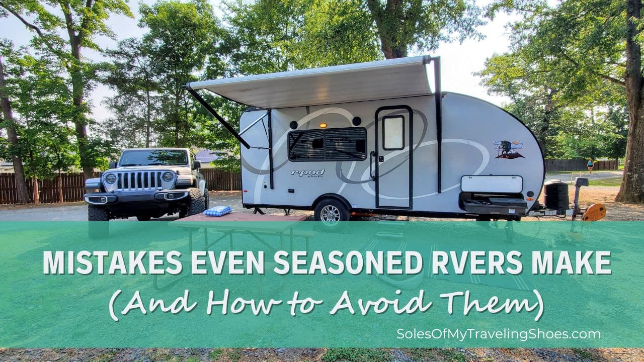 RV with open awning next to silver Jeep