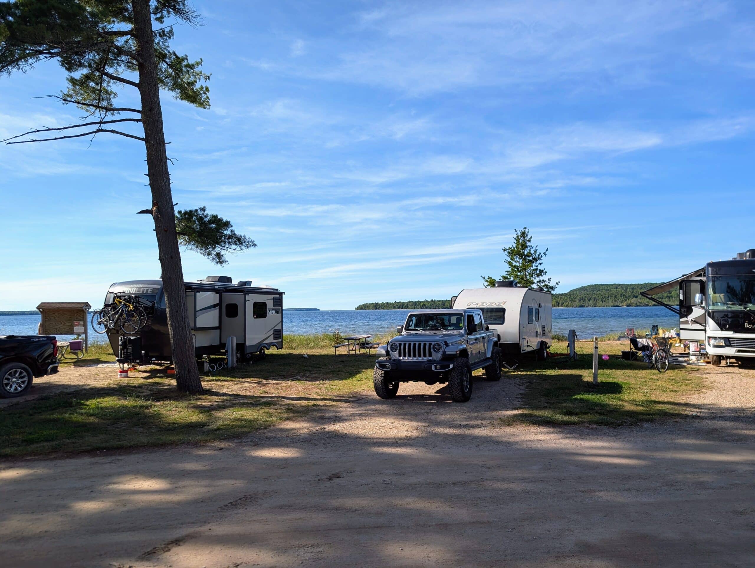 jeep and rpod backed into a campspot against lake superior